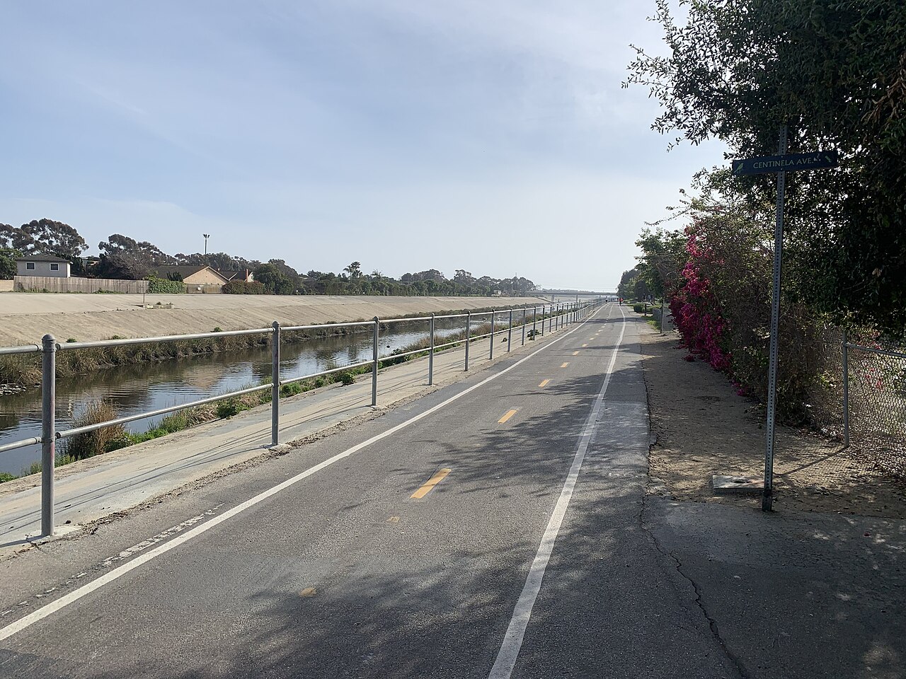 Paved cycling path with center markings beside Ballona Creek