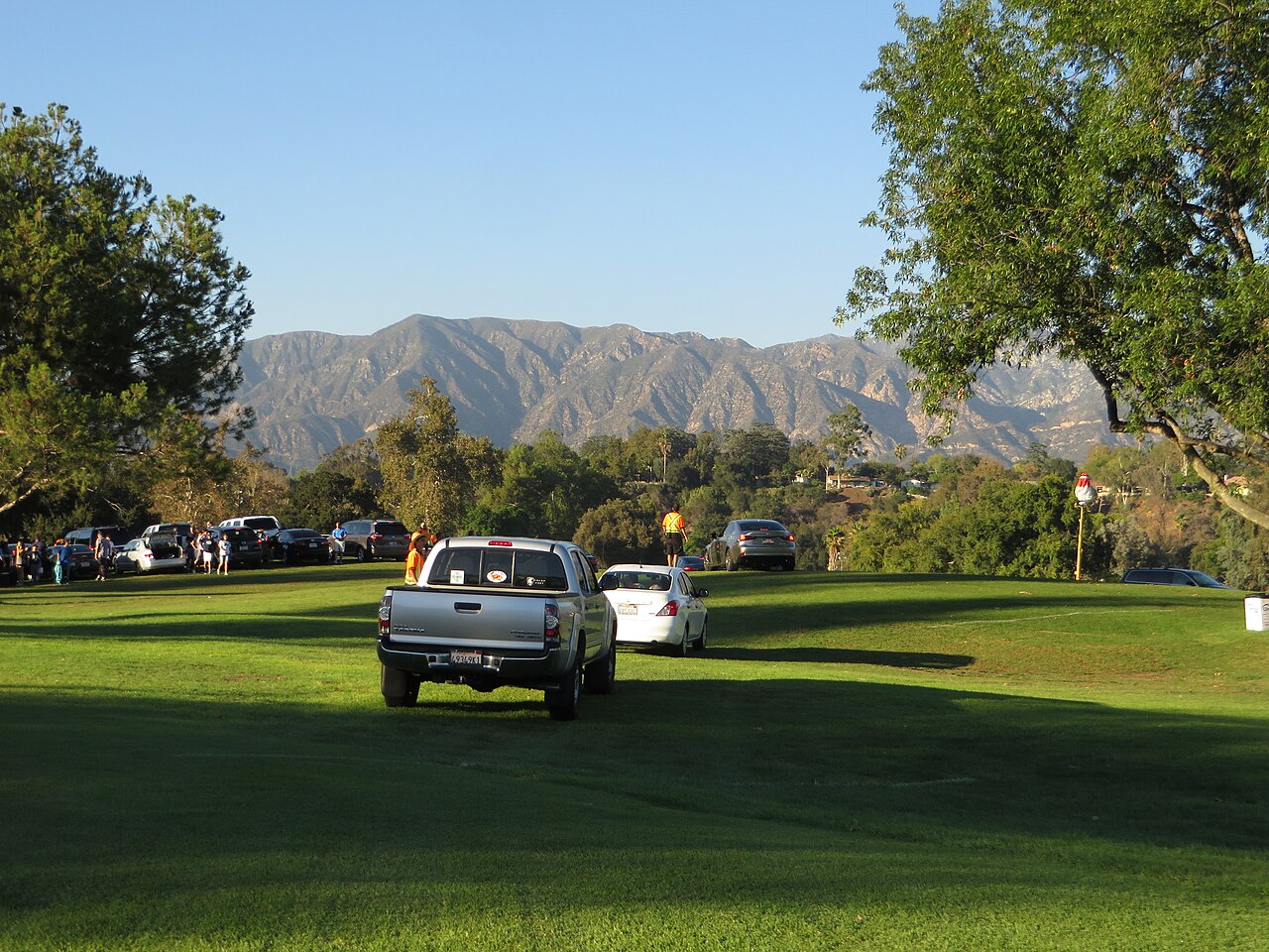 Cars using Brookside golf-course grounds as event parking beside the Rose Bowl loop