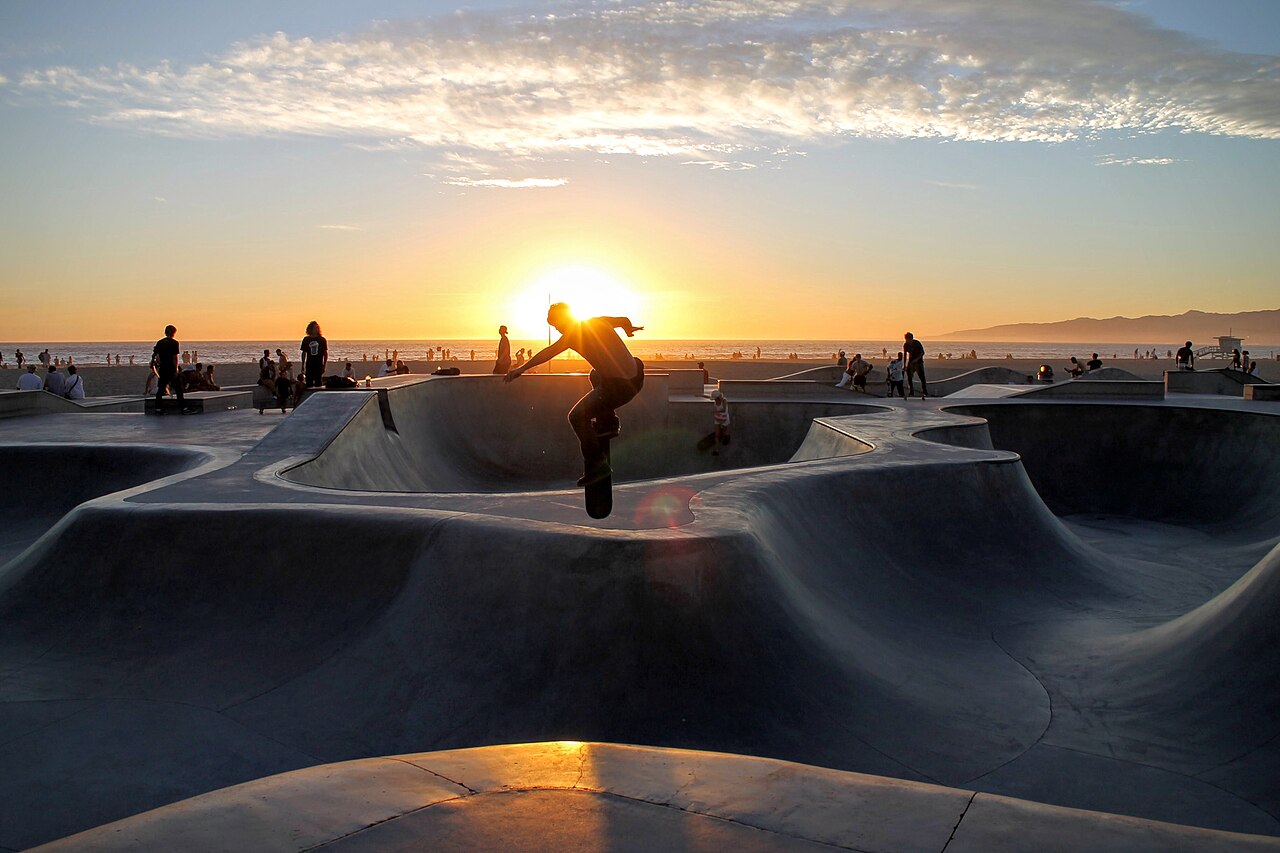 Skate bowls and a skateboarder at Venice Beach near sunset